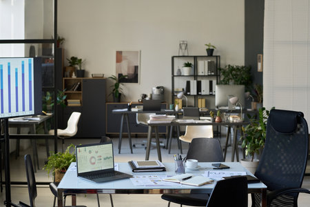 Workplaces of white collar workers with desktop computers, notepads, paper documents and other office supplies on desksの写真素材