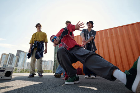 Group of dancers performing hip-hop routines on rooftop space with cityscape in background....