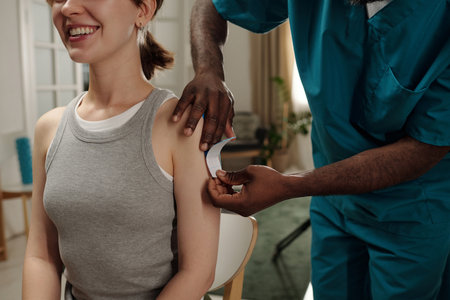Smiling woman sitting in clinic while healthcare professional administering vaccine Home healthcare...