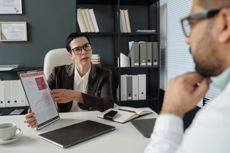 Female Manager Presenting Statistics Report to Employees