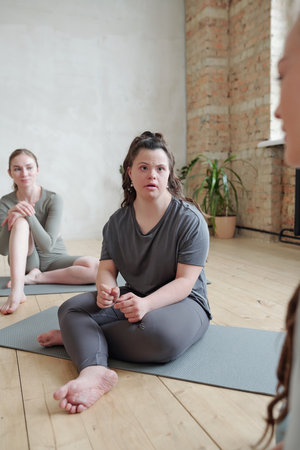 Girl consulting with yoga trainer at break after workoutの写真素材