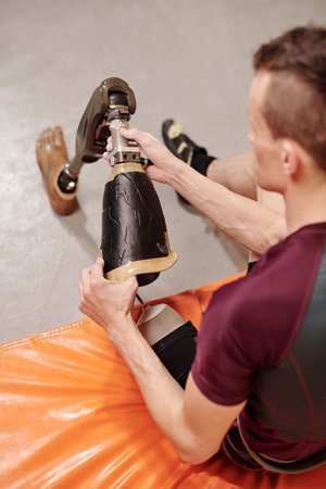 Young disabled climber taking off his robotic legの写真素材