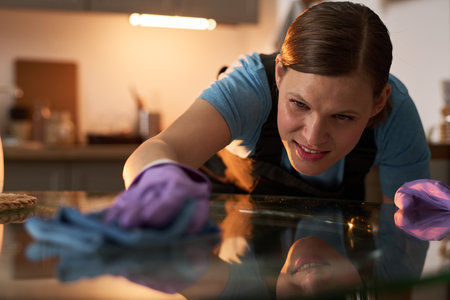 Woman Cleaning Glass Table During Housecleaning