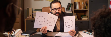 Header of confident psychologist talking to schoolchild and asking him choose one of three different emotions illustrated on papersの写真素材