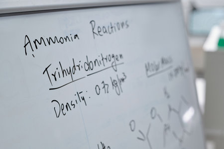 Detailed writing of chemical equations and scientific terms on whiteboard in laboratory setting, showcasing scientific knowledge and expertiseの写真素材