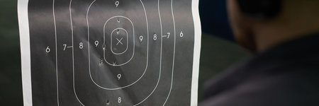 Close-up image shows target used for shooting practice at a firing range with bullet holes...