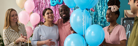 Group of young adult multiethnic friends celebrating gender reveal party, smiling and interactingの写真素材