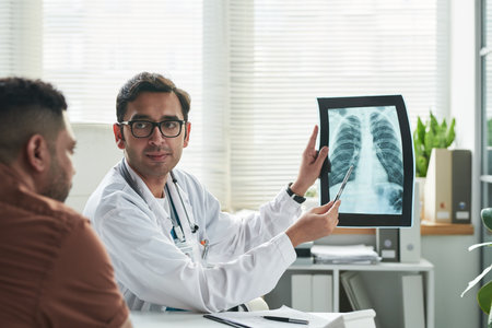 Middle aged Caucasian male doctor explaining chest X-ray results to middle aged man during diabetes...