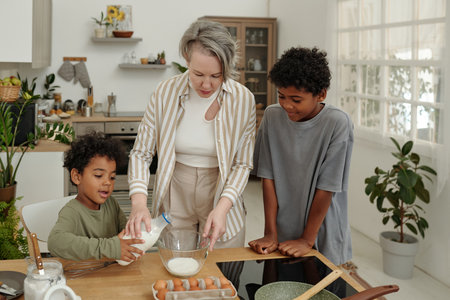 Woman guiding two children in baking activity inside sleek kitchen with wooden and metallic elements...