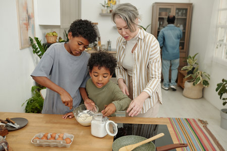 Children and their mother preparing meal by mixing ingredients in cozy kitchen while father walks in...