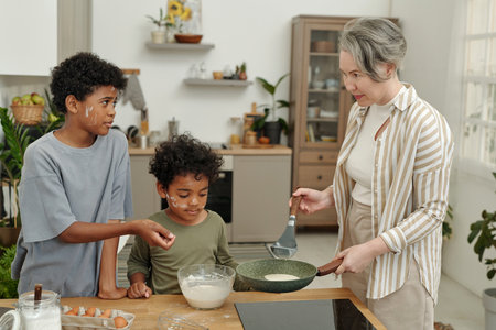 Middle-aged woman showing children cooking techniques in kitchen, one child pointing at bowl and...
