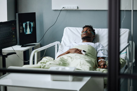 Horizontal shot of young African American man spending days in coma after getting seriously injured in accidentの写真素材