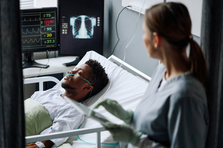High angle selective focus of doctor checking heart rate, blood pressure, oxygen saturation and breath rate of patient after serious surgeryの写真素材