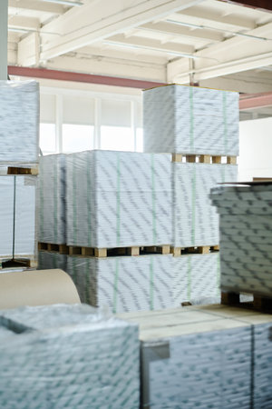 No people shot of piles of packed sheets of paper in modern print shop storehouse, copy space