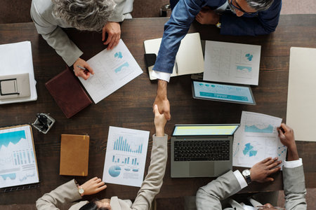 Top view showing group of middle aged multiethnic business professionals collaborating at table, two...