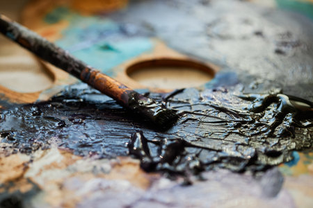 Horizontal close-up shot of old paintbrush, acrylic or oil paints on wooden paletteの写真素材