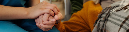 Caucasian young adult woman holding hand of senior Caucasian man, providing support and comfort,...