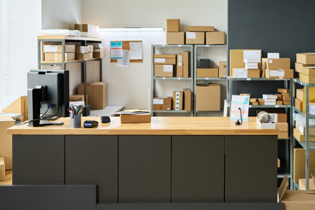 Empty modern shipping office showing wooden counter with desktop computer, payment terminal, barcode...