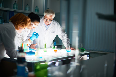 Side view of inspired microbiologists on the way toward new discovery. Young specialists guided by...