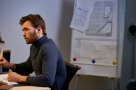 Leading architect explaining main goals for coming month. Confident bearded man in gray turtleneck...