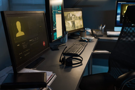 Modern office desk featuring dual computer monitors displaying digital security interface and...