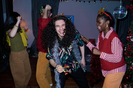 Multiethnic group of young adults dancing during New Year party celebration at home. Image representing holiday friendship suitable for winter event advertising
