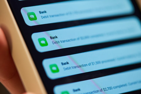 Close up shot of smartphone displaying bank debit transaction notifications on screen. Visual concept represents mobile fintech security and digital banking marketing campaigns