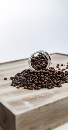 Coffee beans in a glass bottle on wood backgroundの写真素材