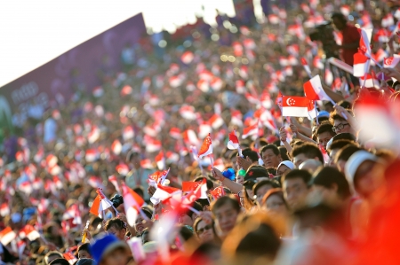 Audience waving Singapore flags during National Day Parade 2012 on August 09, 2012 in Singaporeのeditorial素材