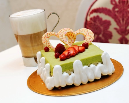 Green tea cake and a cup of cappuccinoの写真素材