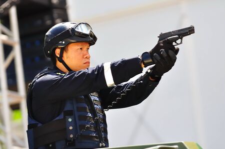 Police officer pointing a revolver during Singapore National Day Parade 2010 at the Padang August 09, 2010 in Singaporeのeditorial素材