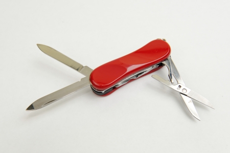 Small red multi-purpose army knife with extended blades and scissorの写真素材