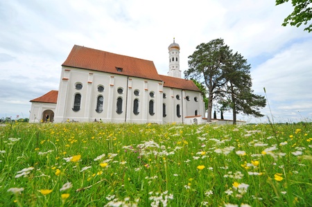 St Colomon church of Bavaria surrounded by meadow with spring flowersの写真素材