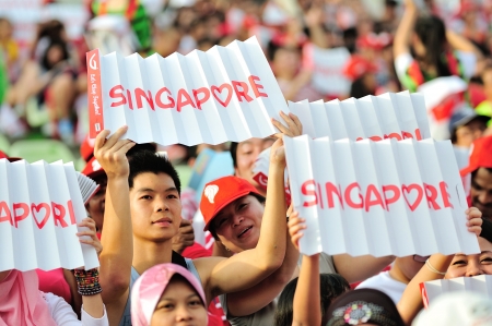 SINGAPORE - JULY 20  Spectators waving Singapore banners during National Day Parade  NDP  Rehearsal...