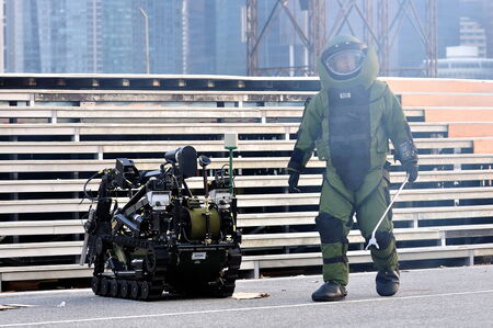 SINGAPORE - JUNE 25: Civil Defence Force (SCDF) CBRE personnel diffusing bomb with the help of robot during National Day Parade Singapore 2011 Combined Rehearsal on June 25, 2011 in Singapore.のeditorial素材