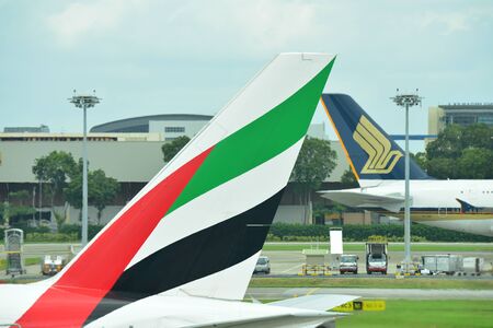 SINGAPORE - JANUARY 10: Tails of Singapore Airlines Airbus 380 and Emirates Boeing 777-300ER at Changi Airport on January 10, 2015 in Singaporeのeditorial素材