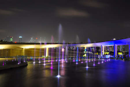 Fountains and bridge at nightの写真素材