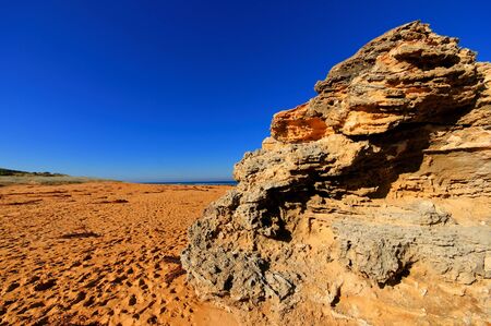 Beautiful beach with footprints and large rocksの写真素材