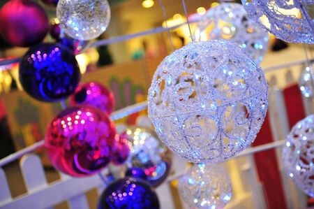 Glittery Christmas balls with colourful bokeh backgroundの写真素材