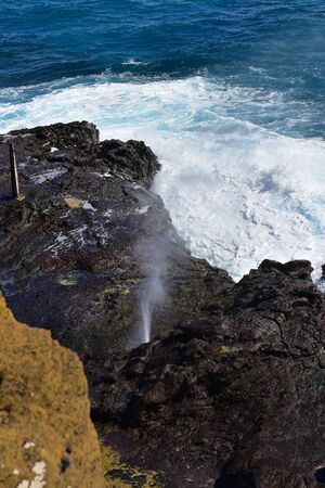 Halona Blowhole spraying water through its lava tube in Oahu, Hawaiiの写真素材