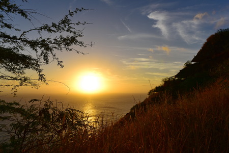 Sun setting above the Pacific Ocean as seen from summit of Diamond Head volcano, Oahu, Hawaii