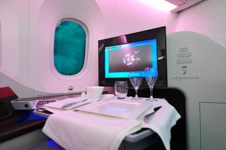 SINGAPORE - FEBRUARY 12: Comfortable business class seat with dining setting onboard Qatar Airways Boeing 787-8 Dreamliner at Singapore Airshow February 12, 2014 in Singaporeのeditorial素材