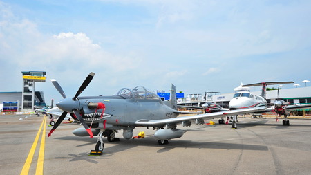 SINGAPORE - FEBRUARY 9: Rows of business and military aircraft on display, including the Beechcraft King Air 350ER and Beechcraft AT-6 Texan II fighter plane at Singapore Airshow February 9, 2014 in Singaporeのeditorial素材