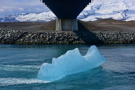 Blue iceberg floating at the mouth of Jokulsarlon Glacier Lagoon in Iceland