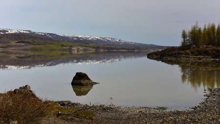 Lake and reflection of hills in eastern fjord in Icelandの写真素材