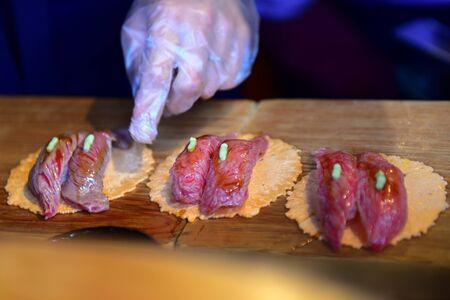 Hida beef sushi on rice cracker being prepared in Takayama, Japan