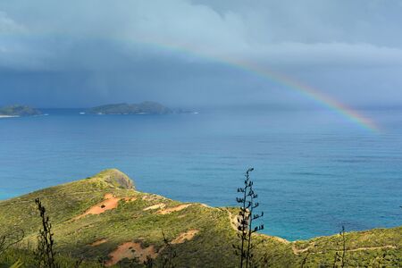 Rainbow appears over Cape Reinga at the northern-most part of New Zealandの写真素材