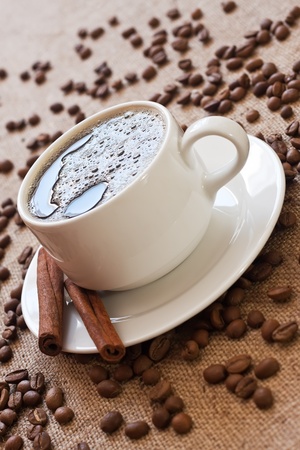 cup of coffee and coffee beans on sacking materialの写真素材
