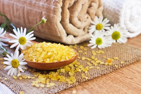 chamomile salt in wooden spoon and roller towels with chamomile on matの写真素材