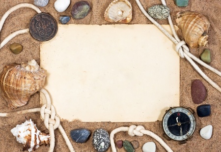 Old paper, sea shells and rope on sand background の写真素材